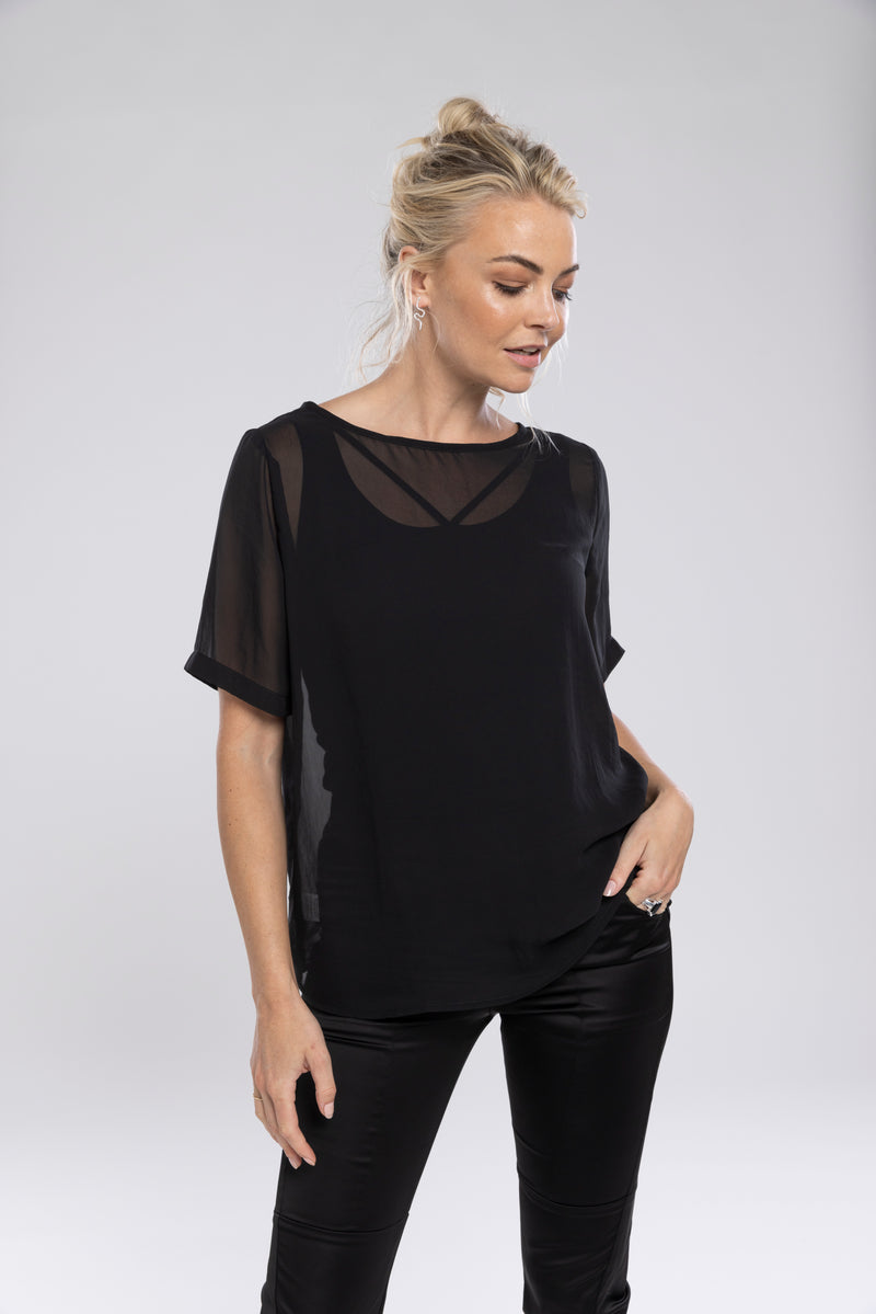NES Charlie Top – Effortlessly Versatile &amp; Elegant

The N-E-S Charlie Top in chiffon is the ultimate versatile addition to your wardrobe. This elegant, lightweight chiffon t-shirt-style top features a straight-across hem and sleeves that finish just above the elbow, offering a relaxed and flattering fit. Perfectly paired with jeans, skirts, or layered under a blazer for a polished office look, it effortlessly adapts to various styles and occasions. Pt chiffon wear back with a lattice singlet