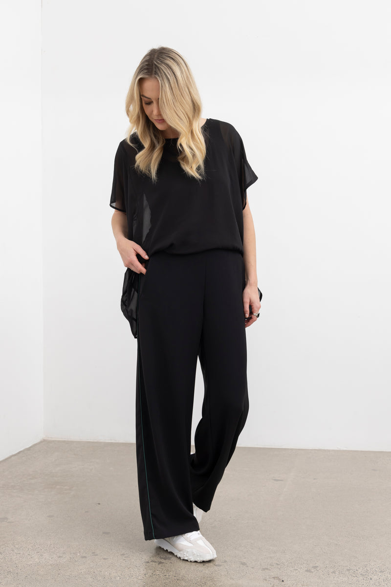 NES Civita Top – Relaxed, Flowing &amp; Versatile

The Civita Top is an effortlessly stylish, oversized piece crafted from lightweight chiffon. Featuring contrast piping along the front vertical seam and split side detailing, this top offers multiple styling options. Tie the sides for a more defined silhouette or tuck it in for a relaxed, easy-going look. Perfect for layering or wearing solo, it transitions seamlessly from day to night, making it ideal for any season. PT CHIFFON nes lattice singlet