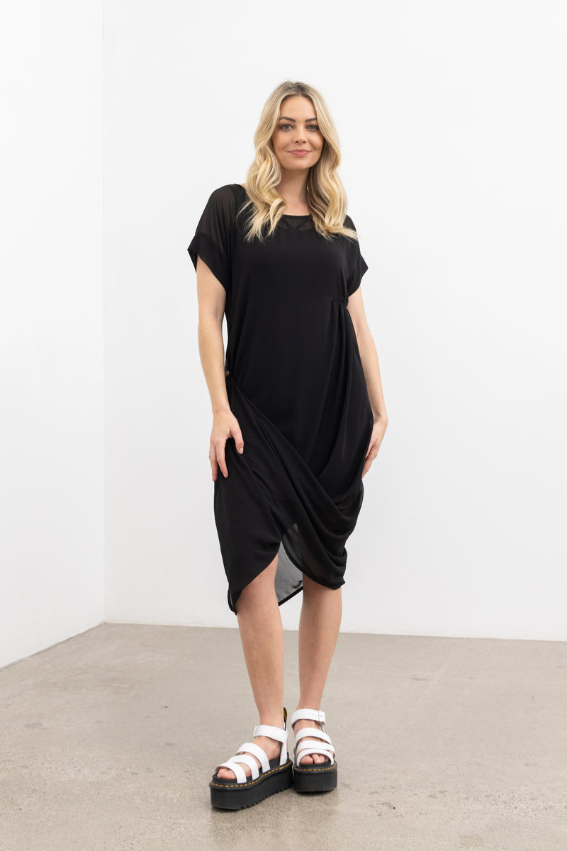 The NES Flow Dress is a multi-seasonal, versatile style that seamlessly transitions from casual to formal occasions. This dress offers a variety of styling options—wear it draped down across the front for a relaxed look, or cinch it up at the side using the adjustable side button and hem loopers for a more structured appearance. The perfect balance of comfort and elegance, this dress can be styled with our Lattice Slip