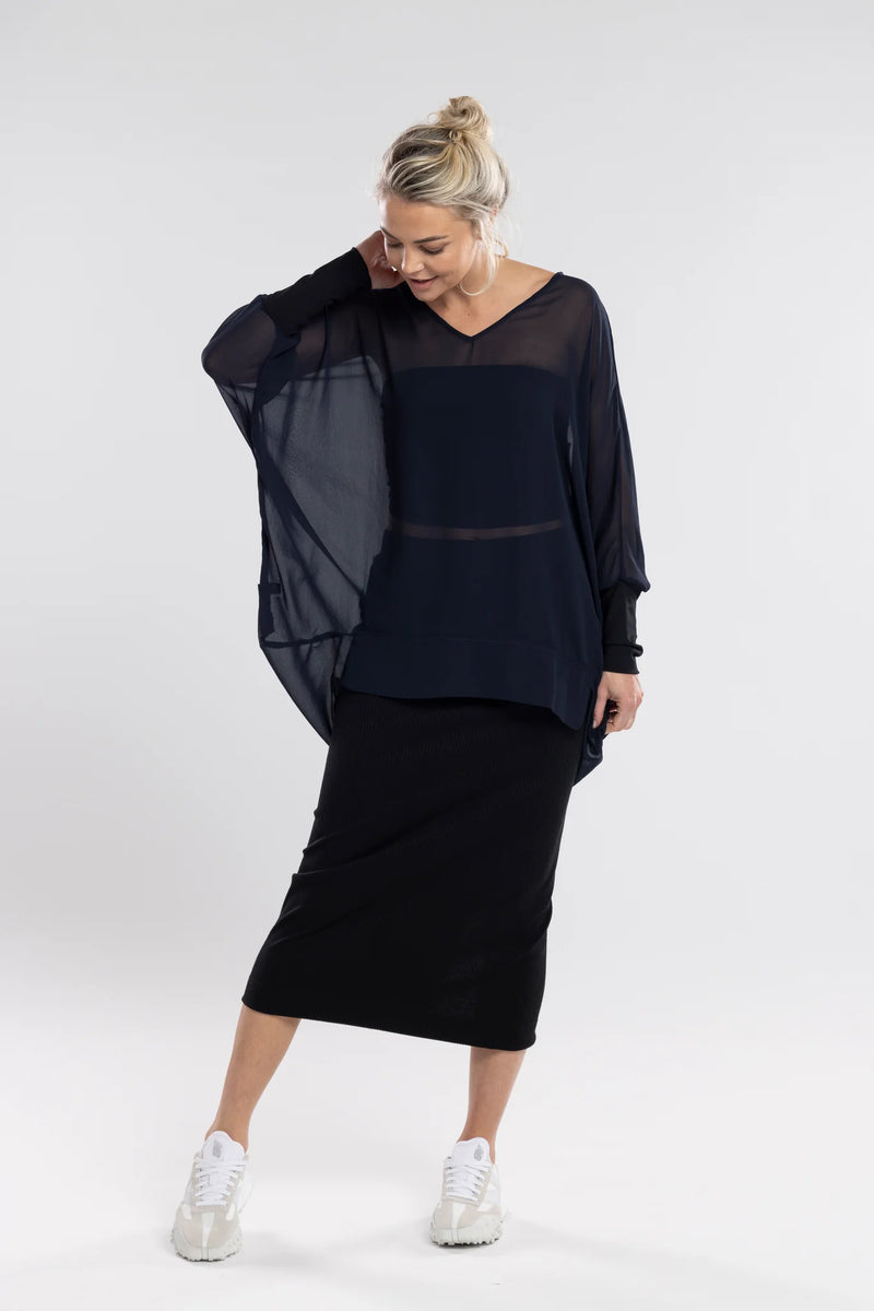 The NES Virtue Tunic is designed to make a statement with its unique reversible style. Featuring a soft V-neckline and batwing 3/4 sleeves, this tunic effortlessly blends comfort and style. The black mesh cuffs add a touch of modern sophistication, while the long, draped back creates a flowing, flattering silhouette. At tunic length, it’s perfect for layering over our NES Lattice Singlet or Electra Slip. Versatile and chic, the Virtue Tunic is a must-have for anyone looking to elevate their wardrobe with ea
