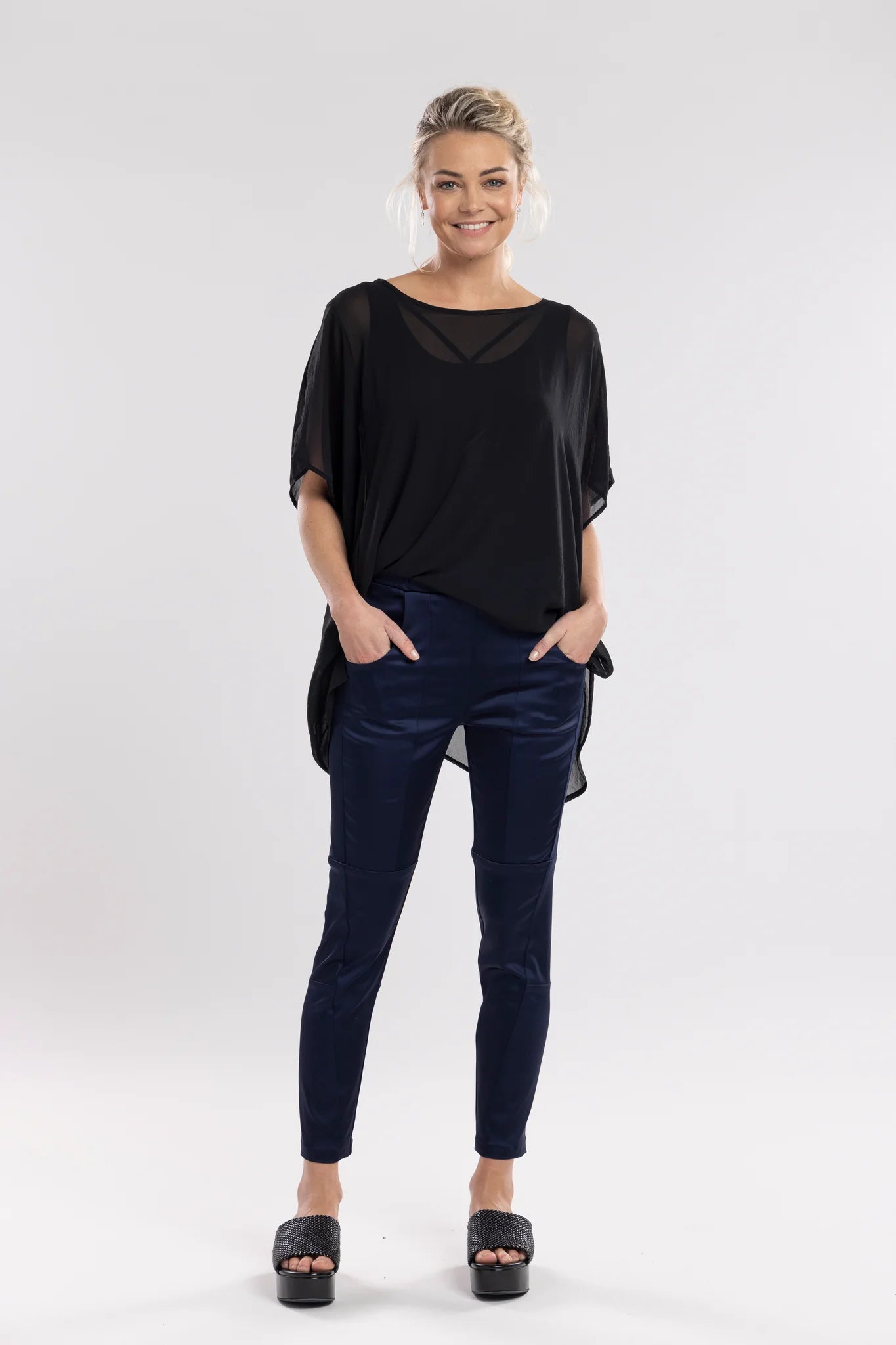 The Satin Section Pant is your go-to slightly more dressy NES essential, offering effortless style and unmatched comfort. With fabulous spliced detailing, this pant combines a sleek flat front with an elasticated back for the perfect fit. Side pockets provide practicality, while the 7/8 length and satin finish add an elevated touch to your look. Whether you're dressing up for a night out, office wear, or a special occasion, these versatile pants can easily be styled for any event. 