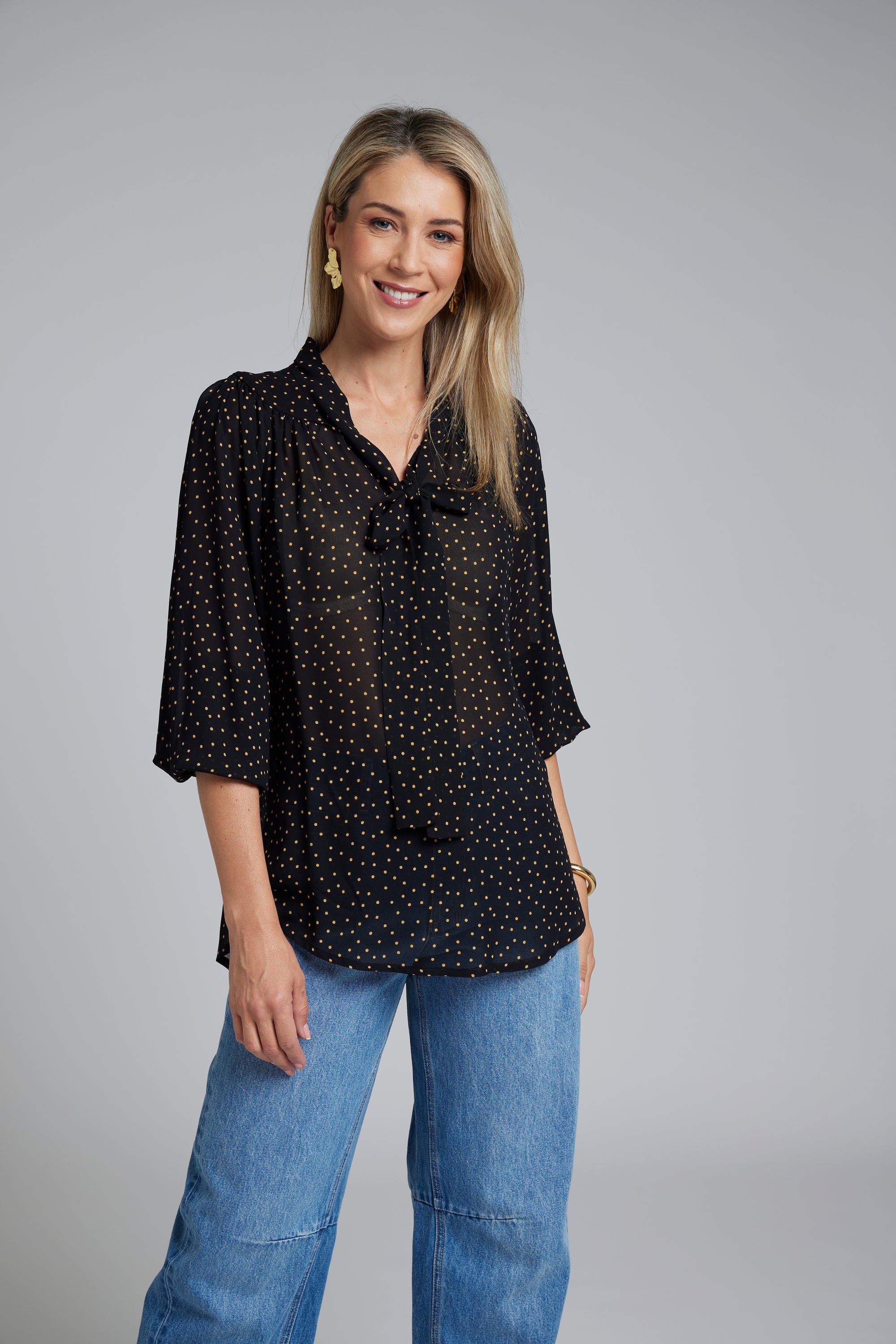 N-E-S Esme Top, designed and made in NZ – a relaxed women’s top with curved front and back hem, finishing just below the waistband; lightweight and breathable, available in Black Polka Dot (100% viscose georgette with butter-yellow mini spots) or Ivory Spot (100% polyester satin-back crepe with bronze oversized spots) for soft drape, gentle movement, and effortless, polished everyday wear.