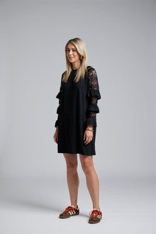NES Luxa Dress by N-E-S – a black merino dress with sculptural ruffled lace sleeves, subtle gathers and above-knee length. Bold, modern and NZ made.