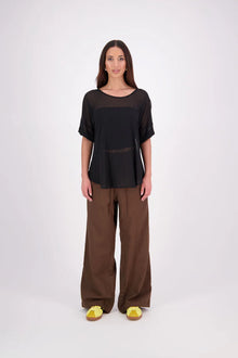 A customer favourite, the NES Cross Top is crafted in lightweight chiffon for an easy, elegant drape. This flattering t-shirt style features mid-length sleeves with folded cuffs, a soft scooped hem, and a unique crossover yoke detail that wraps from front to back. Perfect dressed up or down, and best layered with a NES Lattice Singlet underneath for coverage and style.

Our model is 174cm and wears a XS (8) NES fit advise: Standard fit

Composition: PT Chiffon

Designed and Made in New Zealand