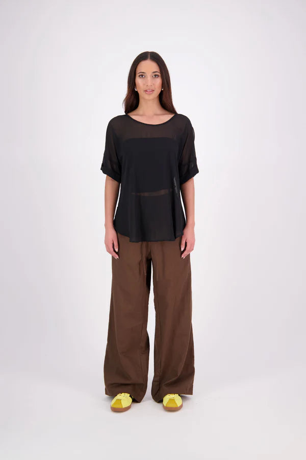 A customer favourite, the NES Cross Top is crafted in lightweight chiffon for an easy, elegant drape. This flattering t-shirt style features mid-length sleeves with folded cuffs, a soft scooped hem, and a unique crossover yoke detail that wraps from front to back. Perfect dressed up or down, and best layered with a NES Lattice Singlet underneath for coverage and style.

Our model is 174cm and wears a XS (8) NES fit advise: Standard fit

Composition: PT Chiffon

Designed and Made in New Zealand