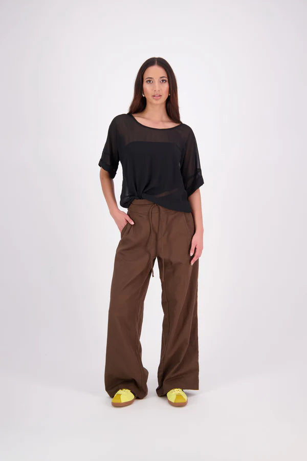 A customer favourite, the NES Cross Top is crafted in lightweight chiffon for an easy, elegant drape. This flattering t-shirt style features mid-length sleeves with folded cuffs, a soft scooped hem, and a unique crossover yoke detail that wraps from front to back. Perfect dressed up or down, and best layered with a NES Lattice Singlet underneath for coverage and style.

Our model is 174cm and wears a XS (8) NES fit advise: Standard fit

Composition: PT Chiffon

Designed and Made in New Zealand