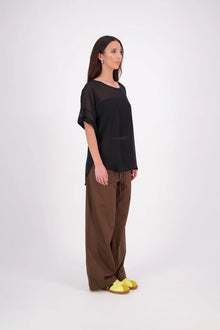 A customer favourite, the NES Cross Top is crafted in lightweight chiffon for an easy, elegant drape. This flattering t-shirt style features mid-length sleeves with folded cuffs, a soft scooped hem, and a unique crossover yoke detail that wraps from front to back. Perfect dressed up or down, and best layered with a NES Lattice Singlet underneath for coverage and style.

Our model is 174cm and wears a XS (8) NES fit advise: Standard fit

Composition: PT Chiffon

Designed and Made in New Zealand