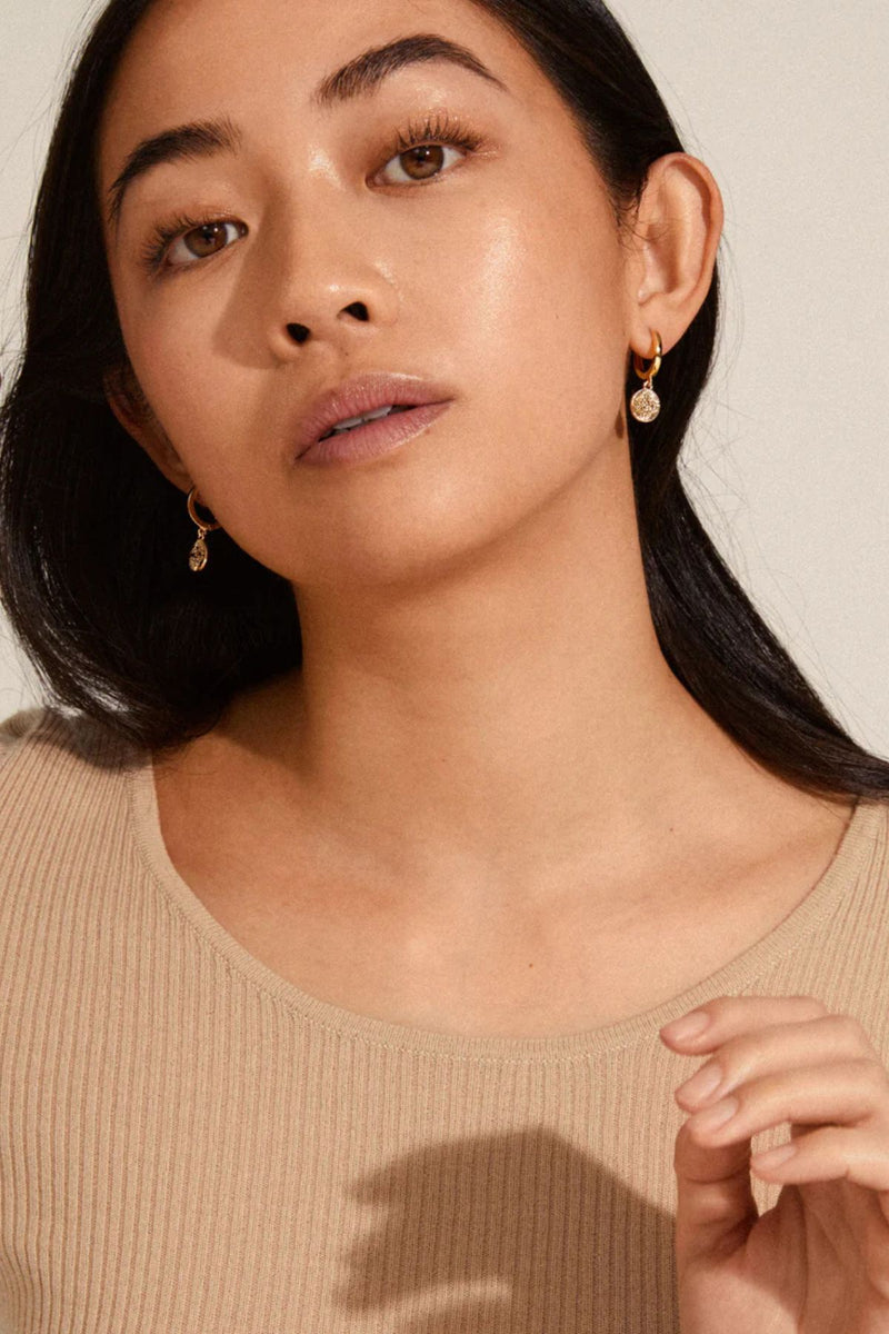 NOMAD coin huggie hoop earrings FROM PILGRIM.
Available in gold-plated &amp; silver-plated with romantic and detailed coin pendants
Classic hoops with a unique twist
The earrings measure 2.5 cm in length
The perfect accessory for any outfit
Style with a little black dress for a beautiful and feminine look