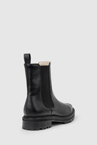 Chaos & Harmony OLLIE Boot, a blend of sustainable fashion and distinctive design. Crafted from black recycled leather, these boots are a testament to both style and environmental consciousness. The square toe shape sets a contemporary tone, offering a unique silhouette that stands out. Black recycled leather chelsea boot, Soft leather lined