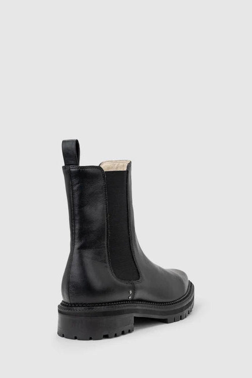 Chaos & Harmony OLLIE Boot, a blend of sustainable fashion and distinctive design. Crafted from black recycled leather, these boots are a testament to both style and environmental consciousness. The square toe shape sets a contemporary tone, offering a unique silhouette that stands out. Black recycled leather chelsea boot, Soft leather lined