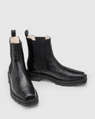 Chaos & Harmony OLLIE Boot, a blend of sustainable fashion and distinctive design. Crafted from black recycled leather, these boots are a testament to both style and environmental consciousness. The square toe shape sets a contemporary tone, offering a unique silhouette that stands out. Black recycled leather chelsea boot, Soft leather lined