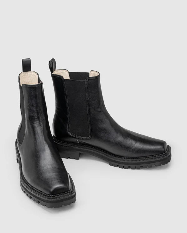 Chaos & Harmony OLLIE Boot, a blend of sustainable fashion and distinctive design. Crafted from black recycled leather, these boots are a testament to both style and environmental consciousness. The square toe shape sets a contemporary tone, offering a unique silhouette that stands out. Black recycled leather chelsea boot, Soft leather lined