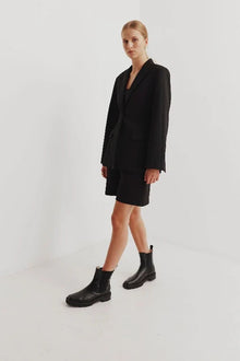Chaos & Harmony OLLIE Boot, a blend of sustainable fashion and distinctive design. Crafted from black recycled leather, these boots are a testament to both style and environmental consciousness. The square toe shape sets a contemporary tone, offering a unique silhouette that stands out. Black recycled leather chelsea boot, Soft leather lined