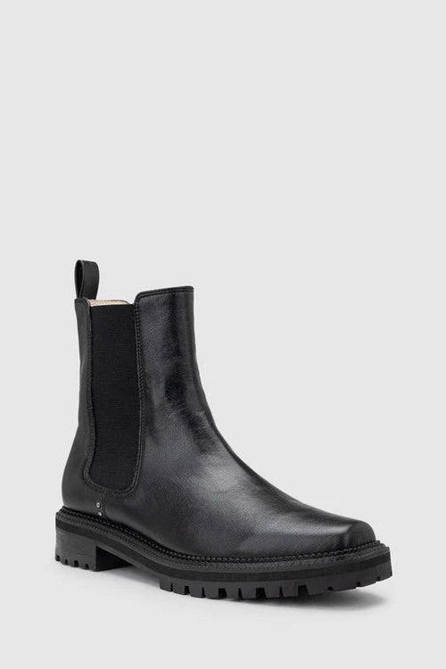 Chaos & Harmony OLLIE Boot, a blend of sustainable fashion and distinctive design. Crafted from black recycled leather, these boots are a testament to both style and environmental consciousness. The square toe shape sets a contemporary tone, offering a unique silhouette that stands out. Black recycled leather chelsea boot, Soft leather lined