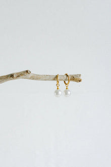 A perfect fusion of modern elegance and timeless charm—the Castel &amp; Co Orb Earrings feature a sleek, polished sphere paired with a delicate pearl drop for effortless sophistication. The contrast between the luminous pearl and the structured orb creates a refined yet contemporary look, making these earrings ideal for both everyday luxury and special occasions. Classic, graceful, and endlessly wearable.

Main material: gold plating, stainless steel
Closure type: congo
Earrings size: 1 x 2.5 cm
Waterproof 