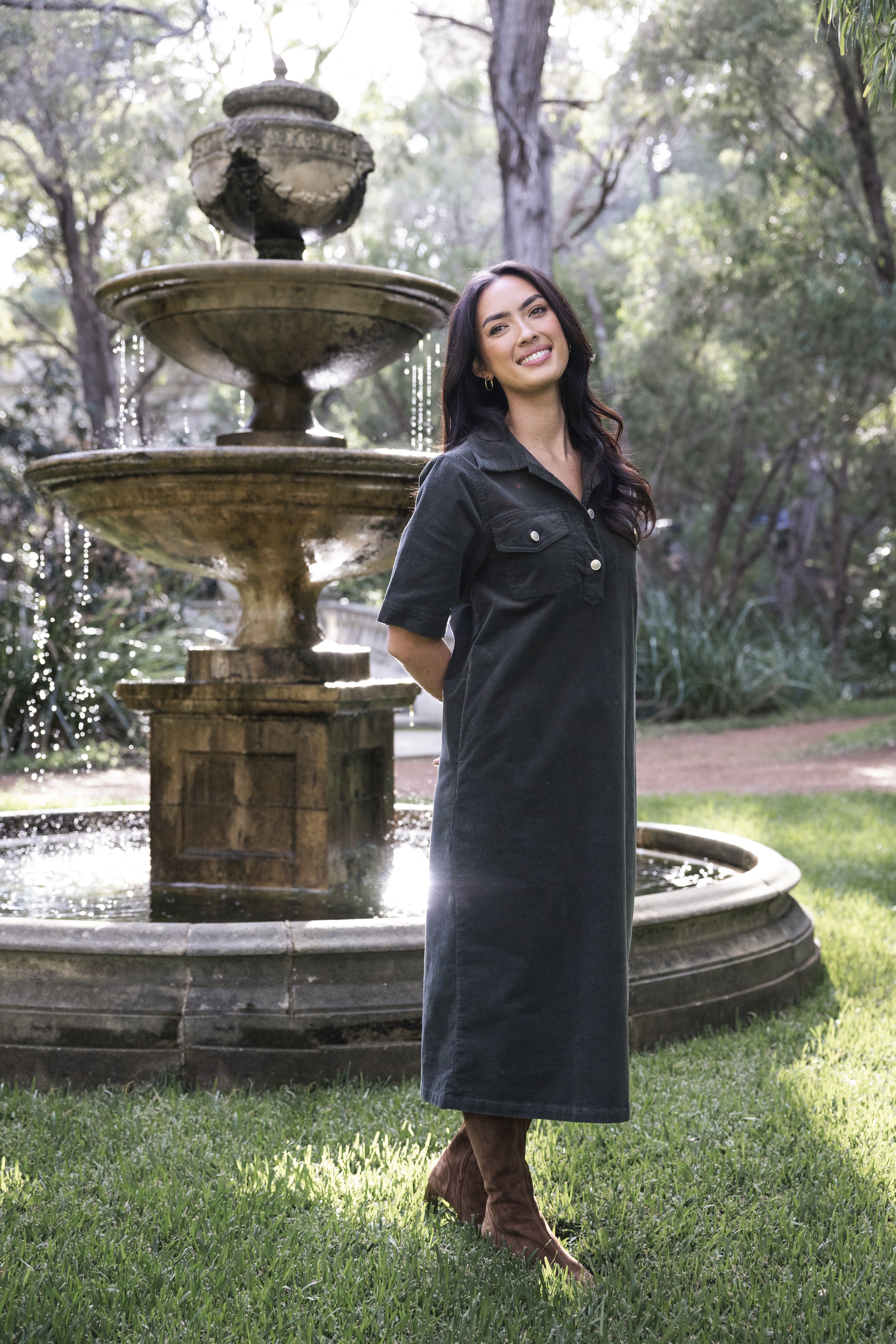Amici Cord Dress in khaki textured cord fabric, featuring a relaxed midi-length silhouette with a collared neckline, half sleeves, and a button-through front. Designed for cooler weather, it includes subtle pockets and a clean, versatile look for everyday wear, styled with boots or layered under a coat. HUMIDITY LIFESTYLE