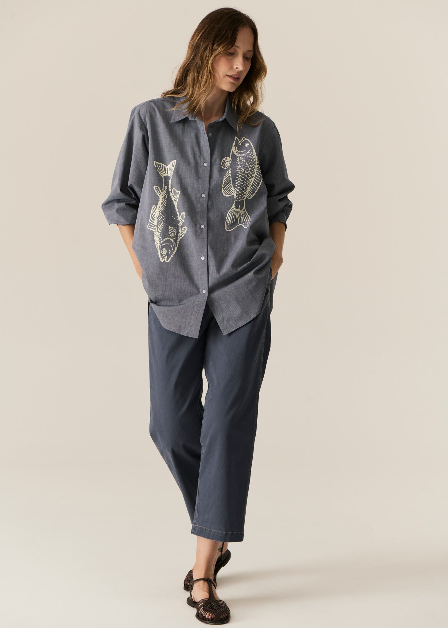 POL CASSIS FISH SHIRT
-Classic shirt collar.
-Button closure through the centre front.
-Gathered detail from yoke at the centre back.
-In-house designed placement fish print on either side at the front.
-Full length sleeves.
-Gathers at the cuffs - two button closure.
-Oversized fit through the body - longline silhouette.
-Hem curves down at the centre back.
-A-line shape.
-Available in Denim/Pebble and Natural/Berry.
100% COTTON