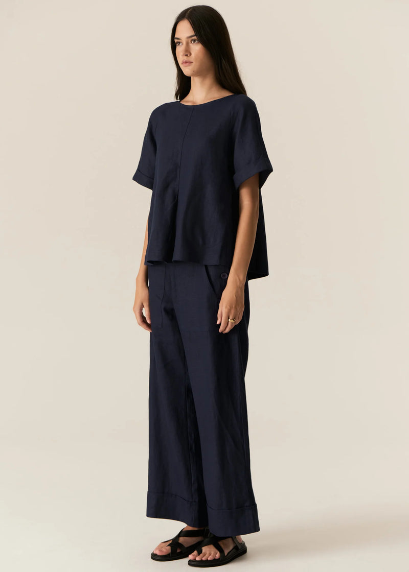 POL | SAGA TOP : -Round neckline.
-Dropped armholes.
-Short sleeves with folded cuff detail.
-Curved hip pockets with topstitching detail.
-Oversized fit - centre front and centre back pleats create a swing shape through the body.
-Styled with the Saga Button Pant.
-Marisa is a size 8 and 179cm wearing a size 8 in the Ink.
-Approximate length in cm by size: 6/59cm, 8/60cm, 10/61cm, 12/62cm, 14/63cm, 16/64cm.
-100% Linen.