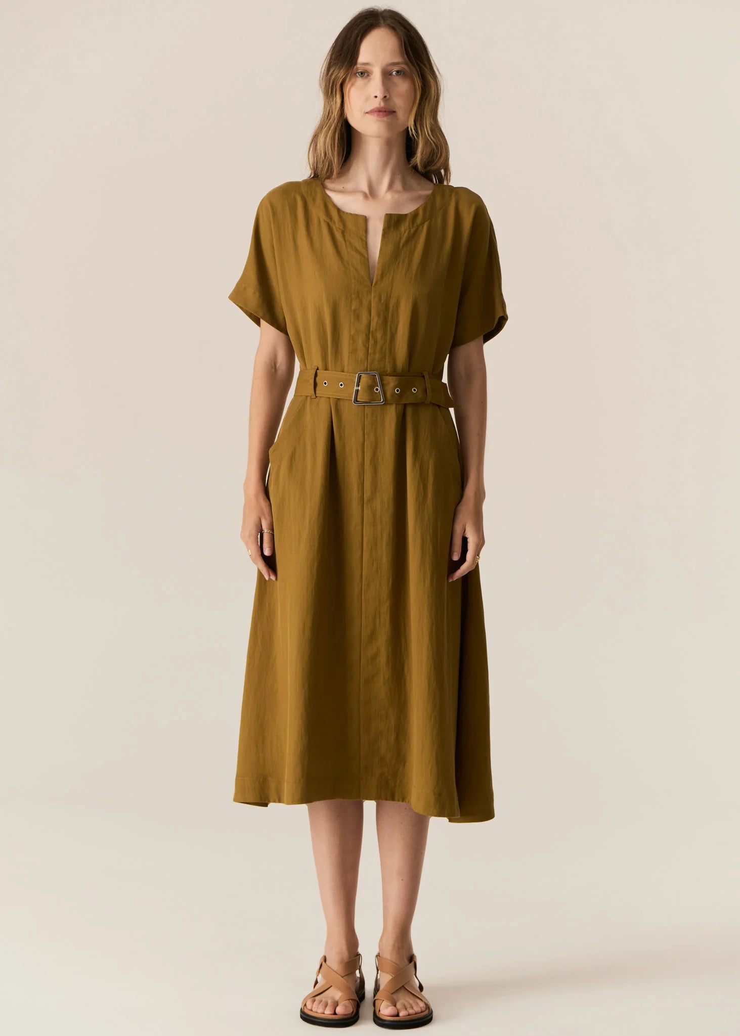 FAIRE BELTED DRESS

Made from a drapey soft suiting, the Faire Belted Dress is an elevated everyday style that can be dressed up or down.
-Slash neckline.
-Short sleeves.
-Relaxed fit can be cinched in with the matching belt.
-Feature nickel buckle on the belt.
-Hip pockets.
-A-line midi length skirt.
-Topstitch detailing throughout.
-Available in Black &amp; Khaki&nbsp;
-Fabric has a natural crinkle texture.