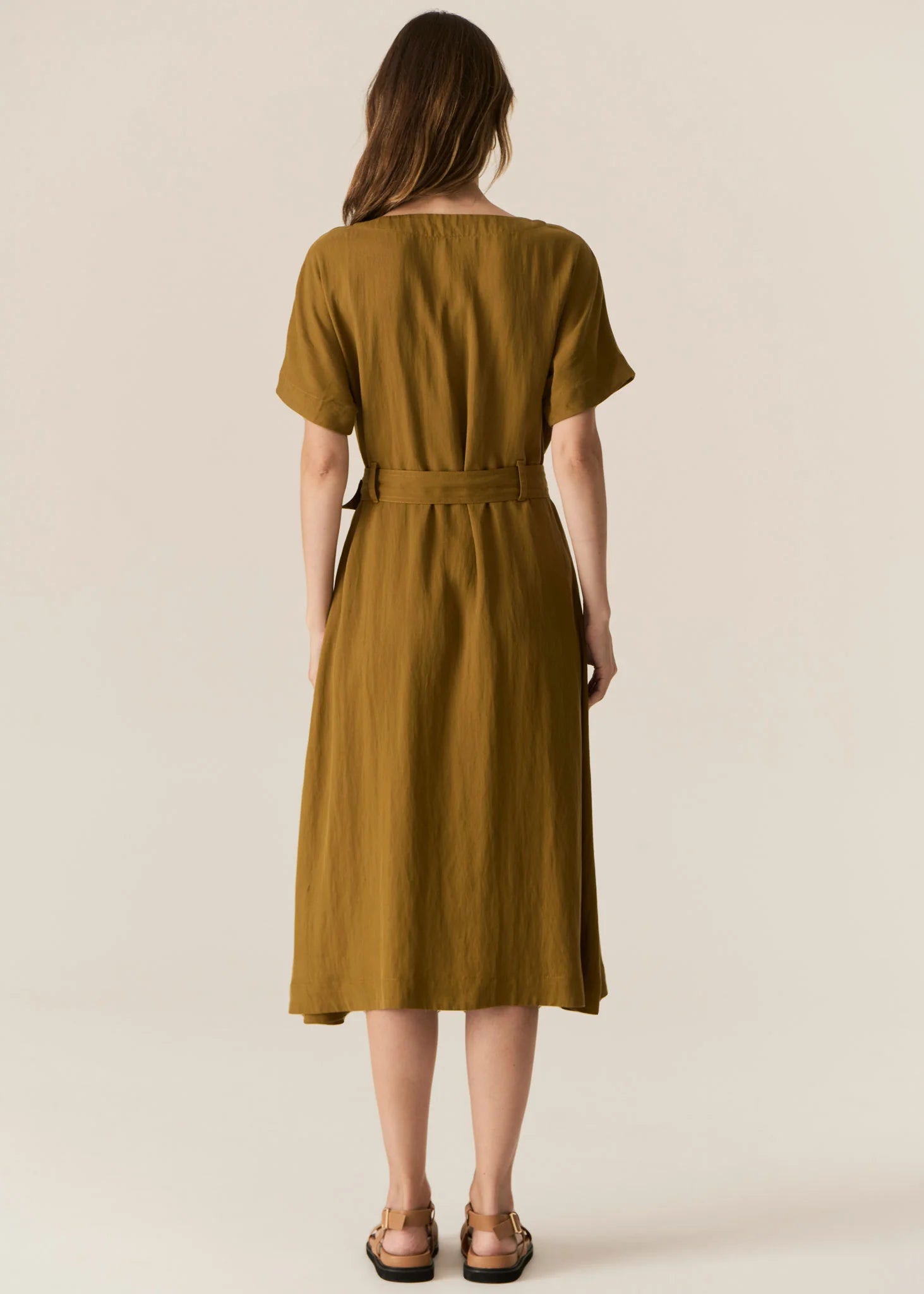 FAIRE BELTED DRESS

Made from a drapey soft suiting, the Faire Belted Dress is an elevated everyday style that can be dressed up or down.
-Slash neckline.
-Short sleeves.
-Relaxed fit can be cinched in with the matching belt.
-Feature nickel buckle on the belt.
-Hip pockets.
-A-line midi length skirt.
-Topstitch detailing throughout.
-Available in Black &amp; Khaki&nbsp;
-Fabric has a natural crinkle texture.