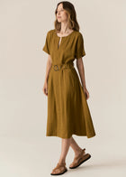 FAIRE BELTED DRESS

Made from a drapey soft suiting, the Faire Belted Dress is an elevated everyday style that can be dressed up or down.
-Slash neckline.
-Short sleeves.
-Relaxed fit can be cinched in with the matching belt.
-Feature nickel buckle on the belt.
-Hip pockets.
-A-line midi length skirt.
-Topstitch detailing throughout.
-Available in Black &amp; Khaki&nbsp;
-Fabric has a natural crinkle texture.