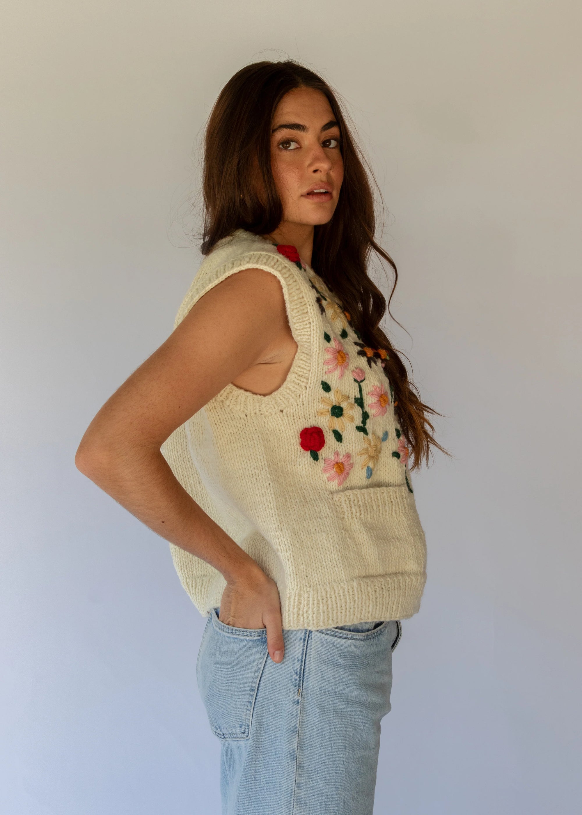 HOBO AND HATCH | Petal Vest - Hand-knitted cream wool vest crafted from 100% New Zealand wool, featuring delicate floral embroidery inspired by spring blooms, coconut button closure, and front patch pockets. Designed with a relaxed silhouette for effortless layering over winter knitwear or pairing with denim. Ethically handcrafted in Nepal alongside local artisans.