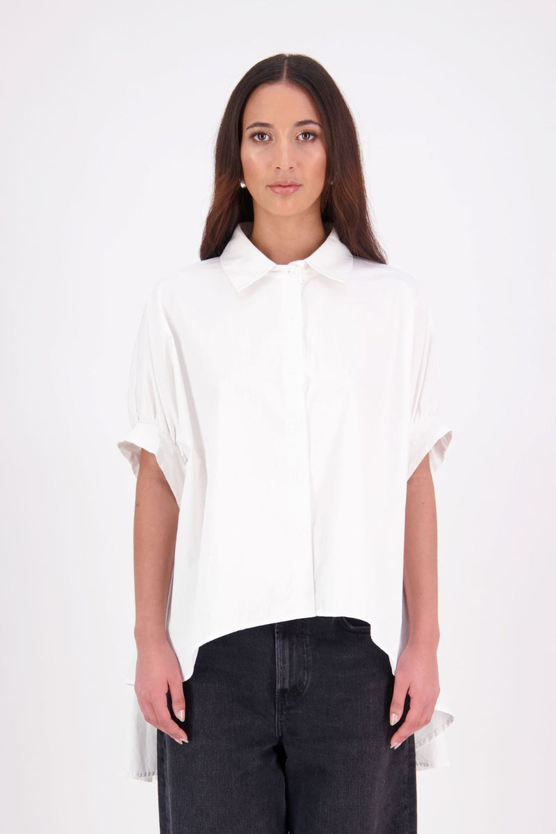 Ryn cotton Shirt – Effortless Volume & Soft Structure

The N-E-S Ryn Shirt is a modern take on a classic, crafted in breathable cotton. With its umbrella-style silhouette, it features a centre front button-down placket, kimono-style sleeves gathered into soft cuffs, and a slight high-low hem. Easy to style back with pants, shorts, or skirts—this is your go-to shirt for relaxed yet elevated dressing.