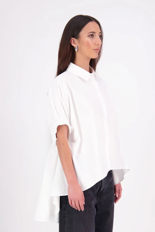 Ryn cotton Shirt – Effortless Volume & Soft Structure

The N-E-S Ryn Shirt is a modern take on a classic, crafted in breathable cotton. With its umbrella-style silhouette, it features a centre front button-down placket, kimono-style sleeves gathered into soft cuffs, and a slight high-low hem. Easy to style back with pants, shorts, or skirts—this is your go-to shirt for relaxed yet elevated dressing.