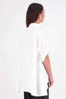 Ryn cotton Shirt – Effortless Volume & Soft Structure

The N-E-S Ryn Shirt is a modern take on a classic, crafted in breathable cotton. With its umbrella-style silhouette, it features a centre front button-down placket, kimono-style sleeves gathered into soft cuffs, and a slight high-low hem. Easy to style back with pants, shorts, or skirts—this is your go-to shirt for relaxed yet elevated dressing.
