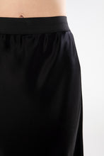 Load image into Gallery viewer, The NES Muse Skirt is the ultimate statement piece—elegant, fluid, and designed to stand out. With a flattering bias cut and a soft concave front that flows into a dropped back hem, this skirt moves beautifully with the body. The wide elasticated waistband offers all-day comfort, while the luxe drape of 100% viscose adds a sophisticated sheen. Multi-seasonal and effortlessly versatile, the Muse Skirt is perfect for pairing with everything from a casual tee to a tailored blazer.

