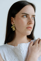Sculptural and dramatic, the Castel & Co Sienna Earrings feature fluid, folded curves in radiant gold plating. Their bold silhouette and organic form create a striking sense of movement, designed to frame the face with modern artistry. A statement earring that embodies elegance with an edge.

Material: Stainless steel, Gold plating
Closure Type: Stud
Earrings Size: 4.5 x 2.5 cm
Waterproof and hypoallergenic
Weight: 7g