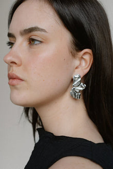 Sculptural and dramatic, the Castel & Co Sienna Earrings feature fluid, folded curves in radiant gold plating. Their bold silhouette and organic form create a striking sense of movement, designed to frame the face with modern artistry. A statement earring that embodies elegance with an edge.

Material: Stainless steel, Gold plating
Closure Type: Stud
Earrings Size: 4.5 x 2.5 cm
Waterproof and hypoallergenic
Weight: 7g