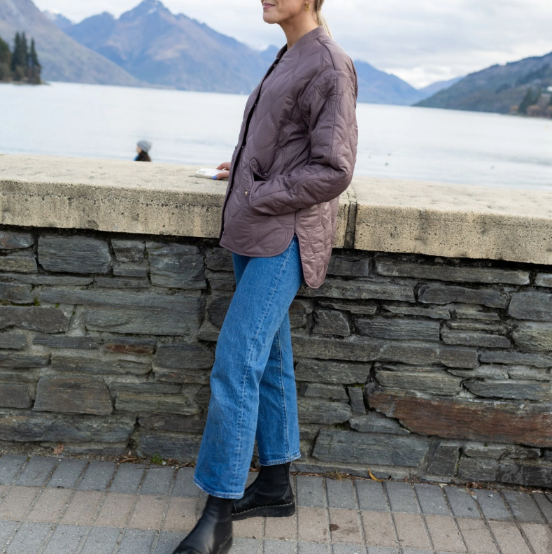 Talei by Moke lightweight quilted bomber jacket in Coco Powder, featuring a relaxed fit with ribbed collar, snap button front and curved silhouette, finished with bound edge detailing and an ultra soft velboa lining for cosy, trans seasonal layering.