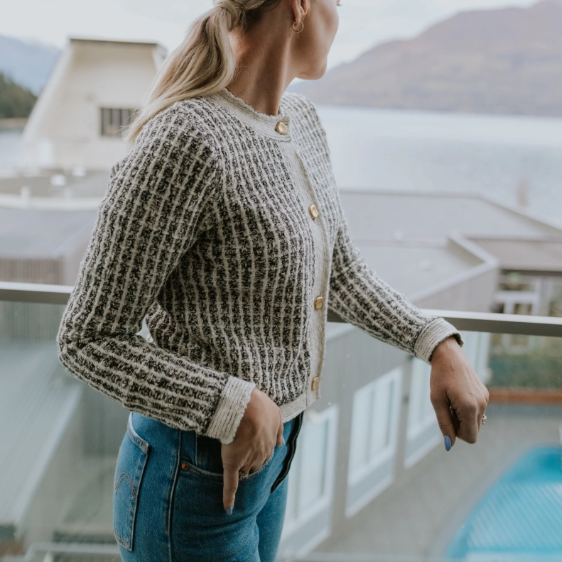 Vivian by Moke women’s cotton blend knit cardigan in white check. Textured novelty knit with a heavier weight feel for warmth and structure, featuring a classic crew neckline and gold finished vintage style buttons at the front. Designed to wear as a cardigan or cosy sweater, this versatile winter staple is made for effortless everyday dressing and designed in New Zealand.