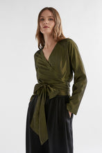 Load image into Gallery viewer, Elevated elegance for the everyday and beyond. The Elk Medjal Top is a sophisticated wrap-style blouse crafted in a striking black and gold palette—designed to shine in evening settings or refined daytime looks. With its flattering wrap silhouette, soft drape, and subtle sheen, it’s the perfect transseasonal piece for effortless dressing.

Made from a luxurious blend of viscose and eco-conscious Ecovero™, the Medjal Top offers breathable comfort with a silky finish. Pair it with tailored trousers or high-wa
