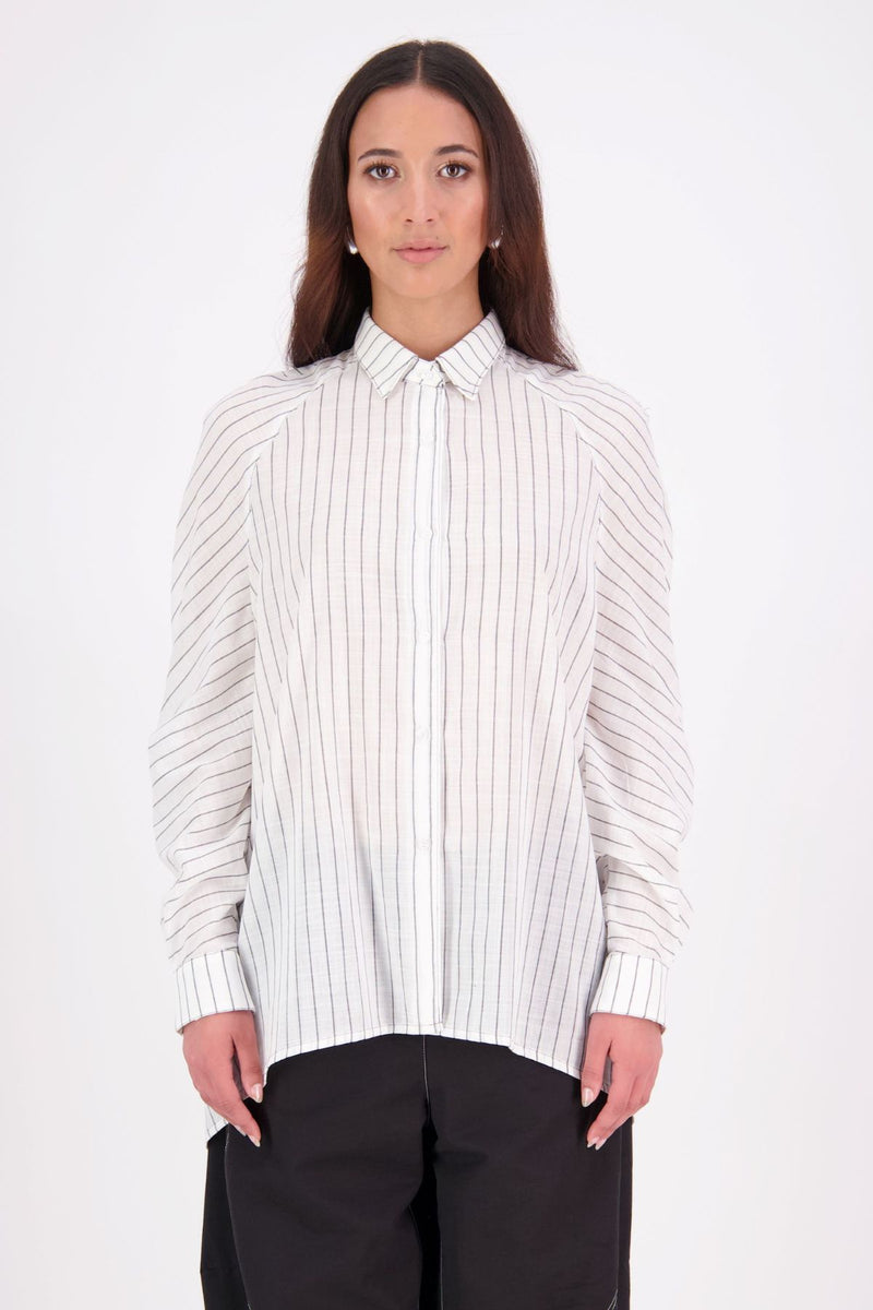 Zola cotton Shirt – Effortless Volume, Elevated Detail

The N-E-S Zola Shirt is a kimono-style oversized shirt with a relaxed, modern silhouette. Featuring a horizontal drop-back panel for added movement, 7/8 sleeves, a classic collar, centre front button placket, and button-up cuffs. A versatile piece that blends structure with flow—perfect for layering or wearing as a statement on its own.