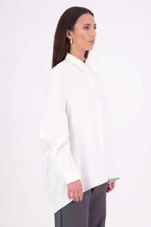 Zola cotton Shirt – Effortless Volume, Elevated Detail

The N-E-S Zola Shirt is a kimono-style oversized shirt with a relaxed, modern silhouette. Featuring a horizontal drop-back panel for added movement, 7/8 sleeves, a classic collar, centre front button placket, and button-up cuffs. A versatile piece that blends structure with flow—perfect for layering or wearing as a statement on its own.