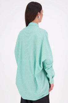 Zola cotton Shirt – Effortless Volume, Elevated Detail

The N-E-S Zola Shirt is a kimono-style oversized shirt with a relaxed, modern silhouette. Featuring a horizontal drop-back panel for added movement, 7/8 sleeves, a classic collar, centre front button placket, and button-up cuffs. A versatile piece that blends structure with flow—perfect for layering or wearing as a statement on its own.