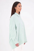 Zola Shirt – Effortless Volume, Elevated Detail

The N-E-S Zola Shirt is a kimono-style oversized shirt with a relaxed, modern silhouette. Featuring a horizontal drop-back panel for added movement, 7/8 sleeves, a classic collar, centre front button placket, and button-up cuffs. A versatile piece that blends structure with flow—perfect for layering or wearing as a statement on its own.