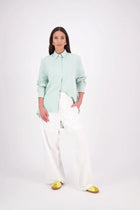 Zola Shirt – Effortless Volume, Elevated Detail

The N-E-S Zola Shirt is a kimono-style oversized shirt with a relaxed, modern silhouette. Featuring a horizontal drop-back panel for added movement, 7/8 sleeves, a classic collar, centre front button placket, and button-up cuffs. A versatile piece that blends structure with flow—perfect for layering or wearing as a statement on its own.