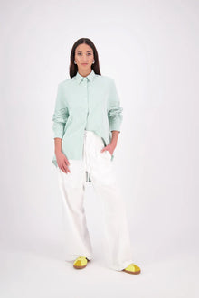 Zola Shirt – Effortless Volume, Elevated Detail

The N-E-S Zola Shirt is a kimono-style oversized shirt with a relaxed, modern silhouette. Featuring a horizontal drop-back panel for added movement, 7/8 sleeves, a classic collar, centre front button placket, and button-up cuffs. A versatile piece that blends structure with flow—perfect for layering or wearing as a statement on its own.