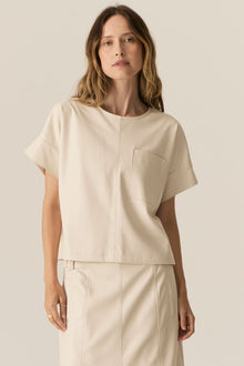 Featuring a soft faux leather in a fresh Ecru shade, the POL Belmond Top has a boxy, t-shirt inspired silhouette.

-Round neckline.
-Covered button fastening at the back neck.
-Dropped armholes.
-Short sleeves finish in a cuff with covered button fastening.
