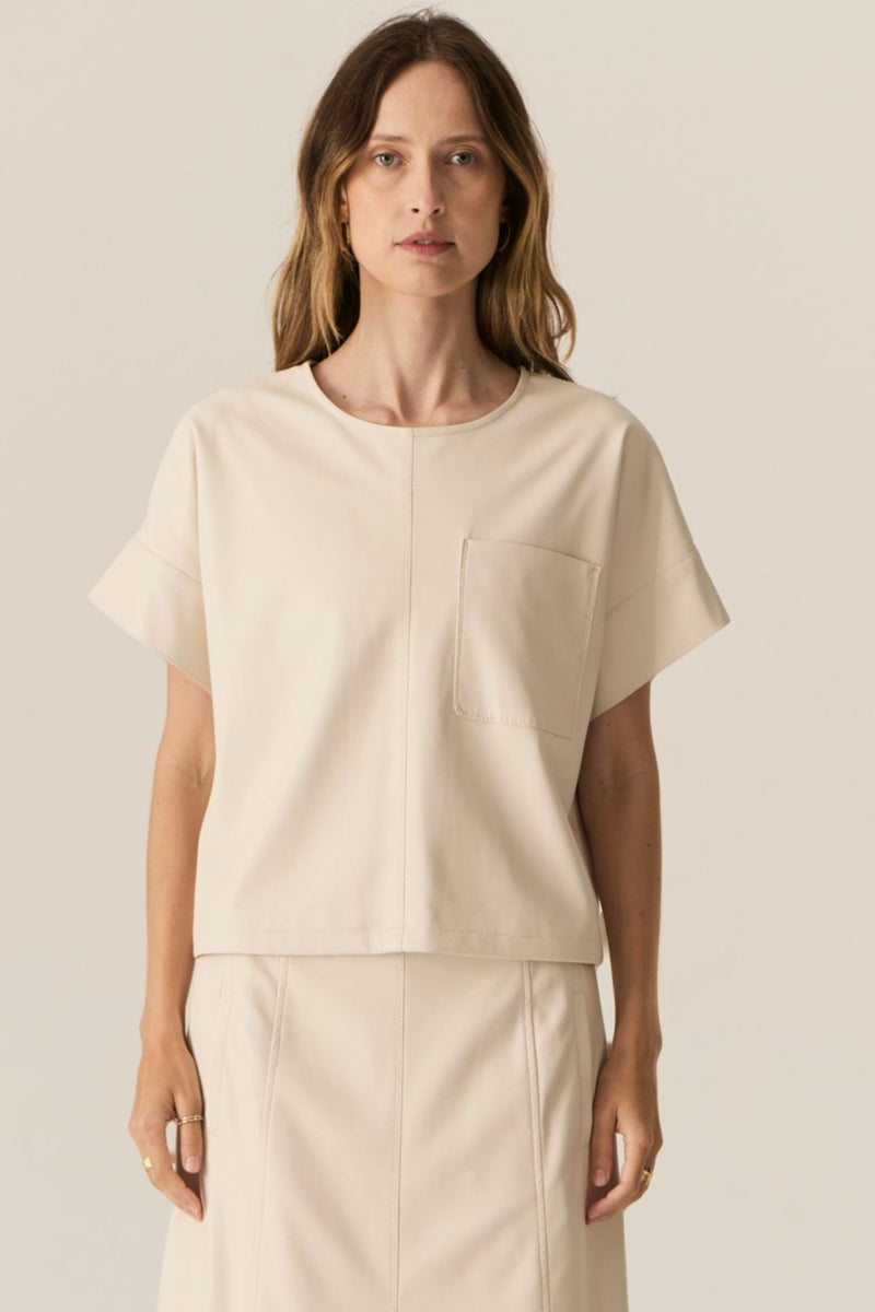 Featuring a soft faux leather in a fresh Ecru shade, the POL Belmond Top has a boxy, t-shirt inspired silhouette.

-Round neckline.
-Covered button fastening at the back neck.
-Dropped armholes.
-Short sleeves finish in a cuff with covered button fastening.