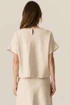 Featuring a soft faux leather in a fresh Ecru shade, the POL Belmond Top has a boxy, t-shirt inspired silhouette.

-Round neckline.
-Covered button fastening at the back neck.
-Dropped armholes.
-Short sleeves finish in a cuff with covered button fastening.