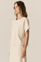 Featuring a soft faux leather in a fresh Ecru shade, the POL Belmond Top has a boxy, t-shirt inspired silhouette.

-Round neckline.
-Covered button fastening at the back neck.
-Dropped armholes.
-Short sleeves finish in a cuff with covered button fastening.