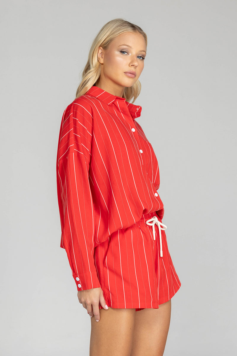 Elevate your style with this must-have BLAK Defiant shirt! Made from a striking red with white pinstripe high quality tencel linen, its relaxed fit and timeless details will make you feel effortlessly cool and infinitely chic. Featuring a drop shoulder, an inverted box pleat in the back, working sleeve cuffs, and a scooped hem, it's a true classic that will fast become your go to shirt.