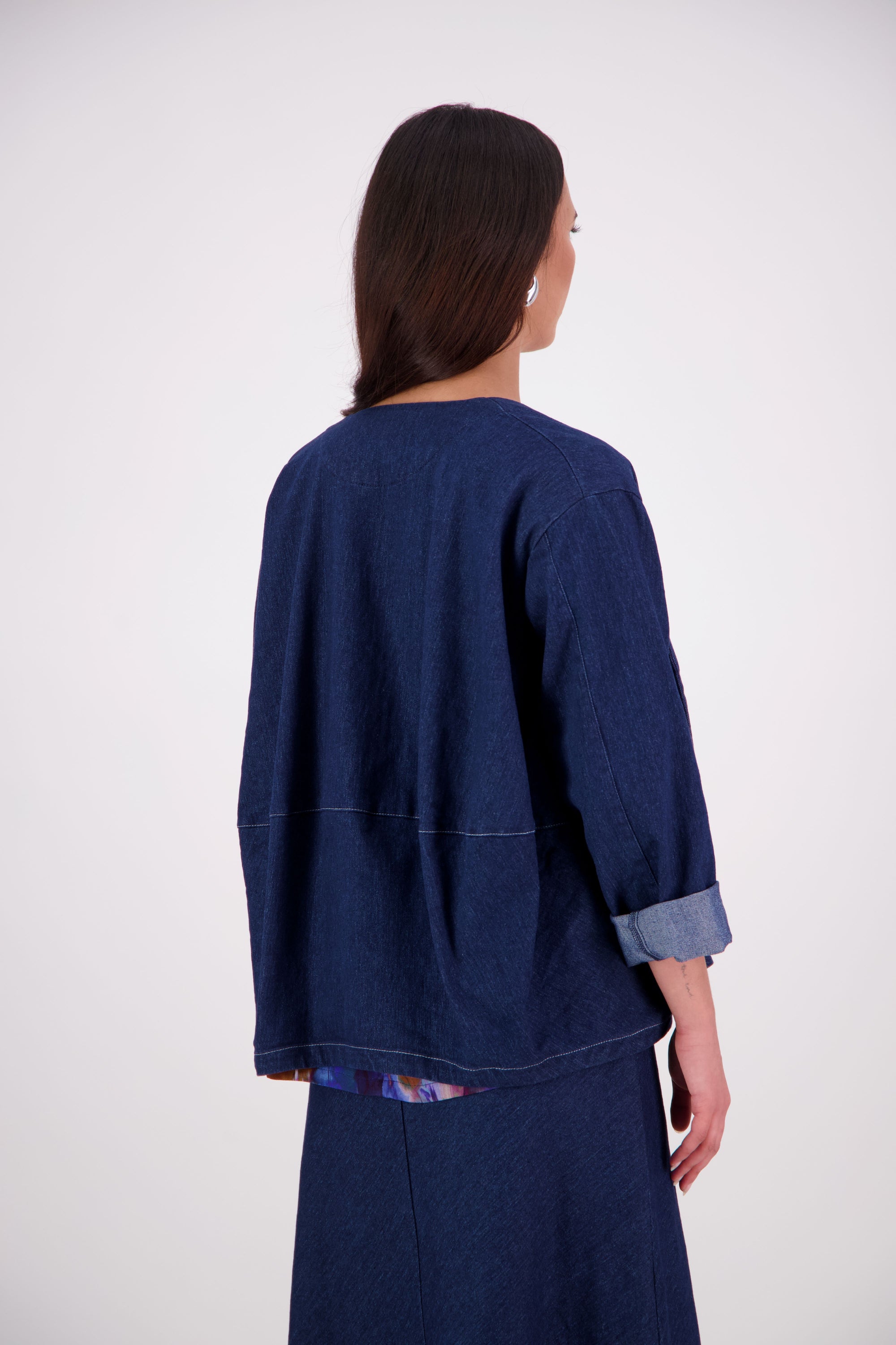 A fresh take on a wardrobe favourite, the NES Denim Echo Jacket now features crisp white topstitching along the hemlines for a modern contrast finish. Crafted in lightweight denim, this relaxed open-front jacket includes practical pockets and a subtle ballooning back panel for added shape. The perfect throw-on layer that effortlessly blends casual cool with elevated edge.