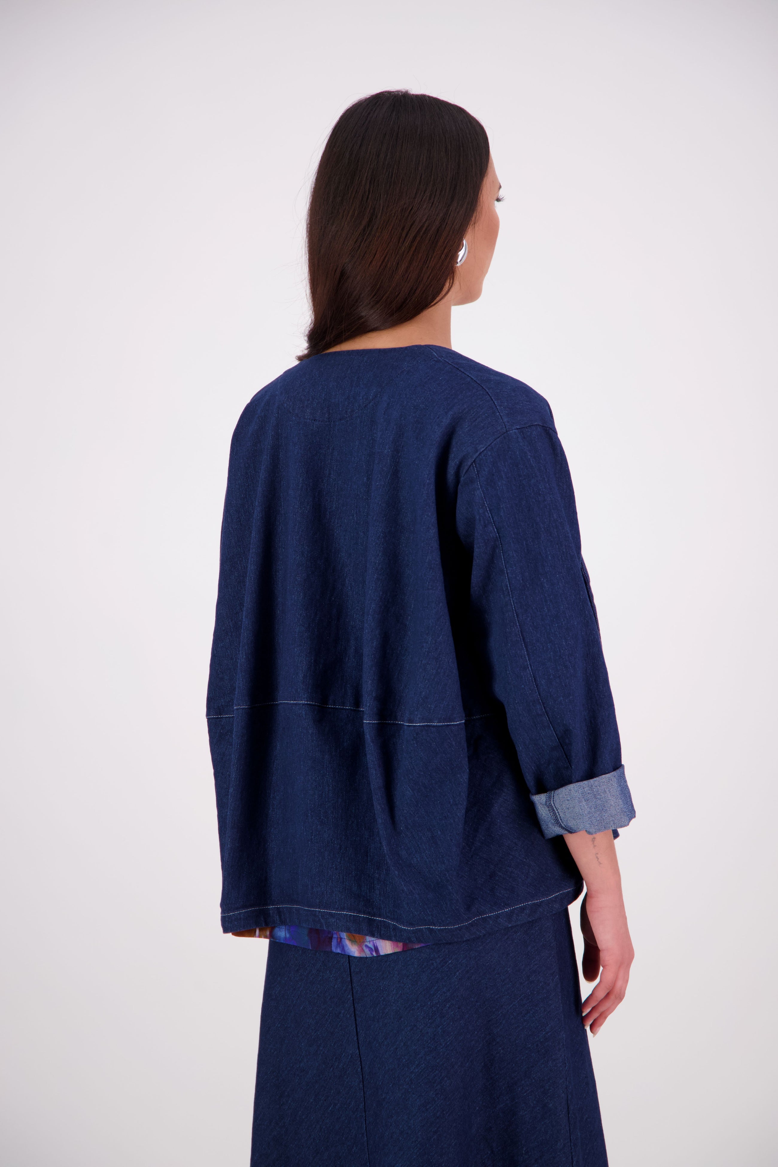 A fresh take on a wardrobe favourite, the NES Denim Echo Jacket now features crisp white topstitching along the hemlines for a modern contrast finish. Crafted in lightweight denim, this relaxed open-front jacket includes practical pockets and a subtle ballooning back panel for added shape. The perfect throw-on layer that effortlessly blends casual cool with elevated edge.