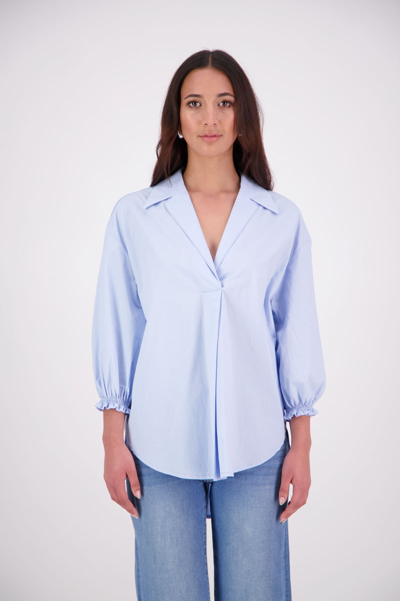 The N-E-S Fara Shirt blends classic tailoring with soft, modern touches. Featuring 7/8 sleeves with three layers of shirring at the cuffs, a traditional collar flowing into an open V-neck and centre front pleat. The drop-back design reveals a cross-over keyhole and centre back button detail. Style the sleeves your way—worn down, ruched up, or tucked under—for versatile, effortless dressing.
Composition: Sky (fine seersucker) - cotton, spandex | Oyster grey stripe cotton, polyamide, elastine.