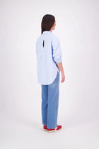 The N-E-S Fara Shirt blends classic tailoring with soft, modern touches. Featuring 7/8 sleeves with three layers of shirring at the cuffs, a traditional collar flowing into an open V-neck and centre front pleat. The drop-back design reveals a cross-over keyhole and centre back button detail. Style the sleeves your way—worn down, ruched up, or tucked under—for versatile, effortless dressing.
Composition: Sky (fine seersucker) - cotton, spandex | Oyster grey stripe cotton, polyamide, elastine.